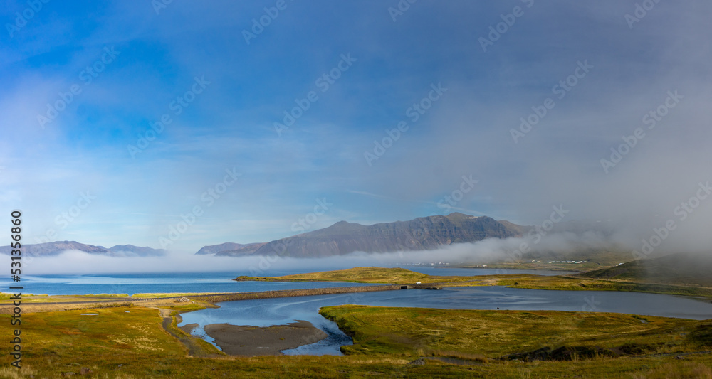mist over the ocean with road passing over tidal pools