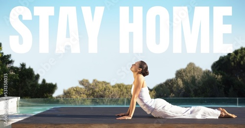 Fotografie Caucasian woman practising yoga with words Stay Home during coronavirus covid19