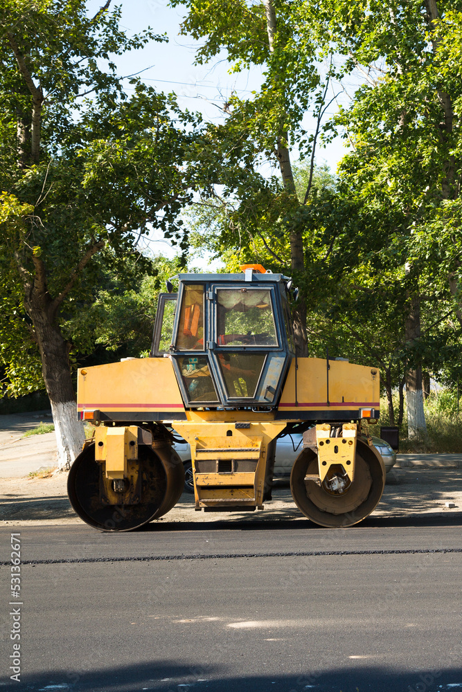 An asphalt paver is a skating rink for repairing roads on streets of the city standing idle during lunch break. An asphalt paver is a skating rink for repairing roads on streets of the city standing idle during lunch break.
