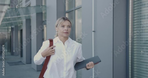 Senior Business Woman Late Outdoor. Blonde Manager Walking In Hurry On City Street. Business Lady Looking Rapidly At Wristwatch. Busy Woman In Hurry To Appointment 