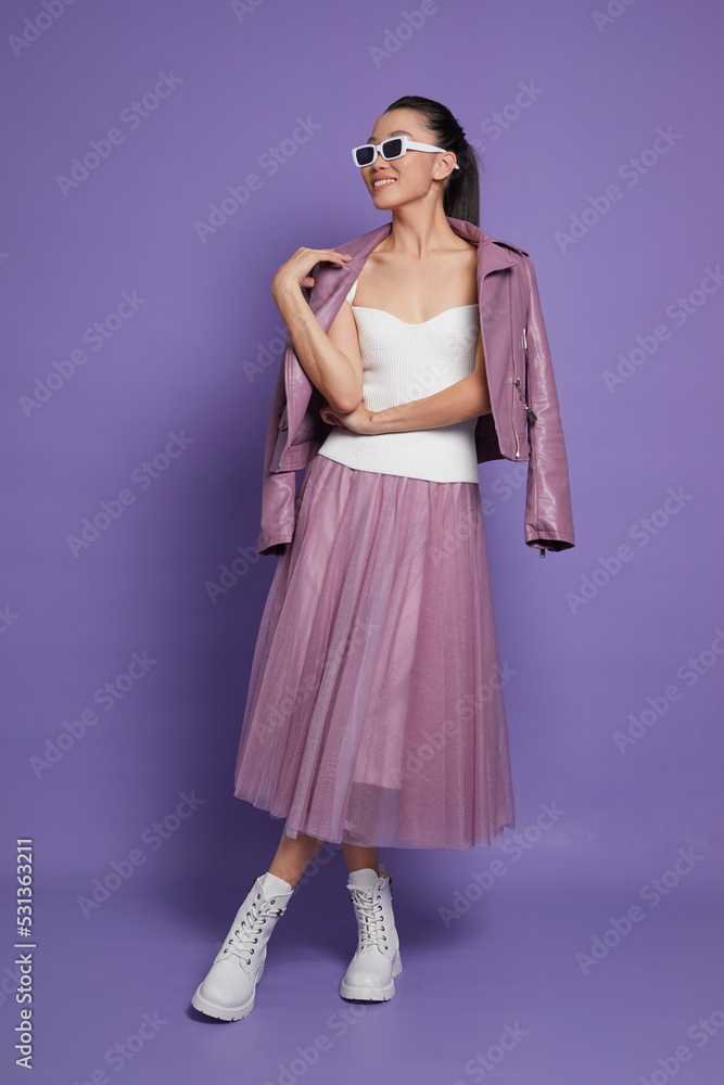 Fashion asian female model. Lilac leather jacket, lilac skirt, white boots, sunglasses. Fashion asian female model. Lilac leather jacket, lilac skirt, white boots, sunglasses.