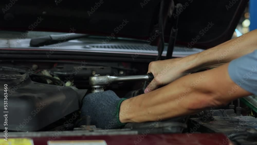 Slow motion. Closeup hand and spanner. Engineer mechanic male repairs and service car in garage. Car maintenance and auto service garage concept. Slow motion. Closeup hand and spanner. Engineer mechanic male repairs and service car in garage. Car maintenance and auto service garage concept.