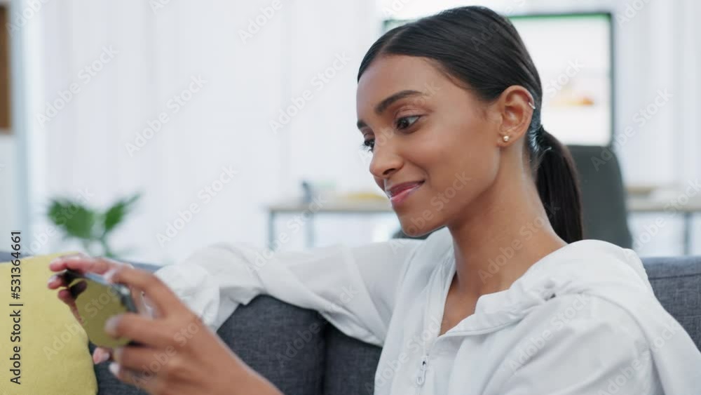 Woman, phone and social media entertainment on sofa relaxing to watch or play games with wifi at home. Happy female browsing and rotating mobile smartphone for game, video call or movie streaming Woman, phone and social media entertainment on sofa relaxing to watch or play games with wifi at home. Happy female browsing and rotating mobile smartphone for game, video call or movie streaming