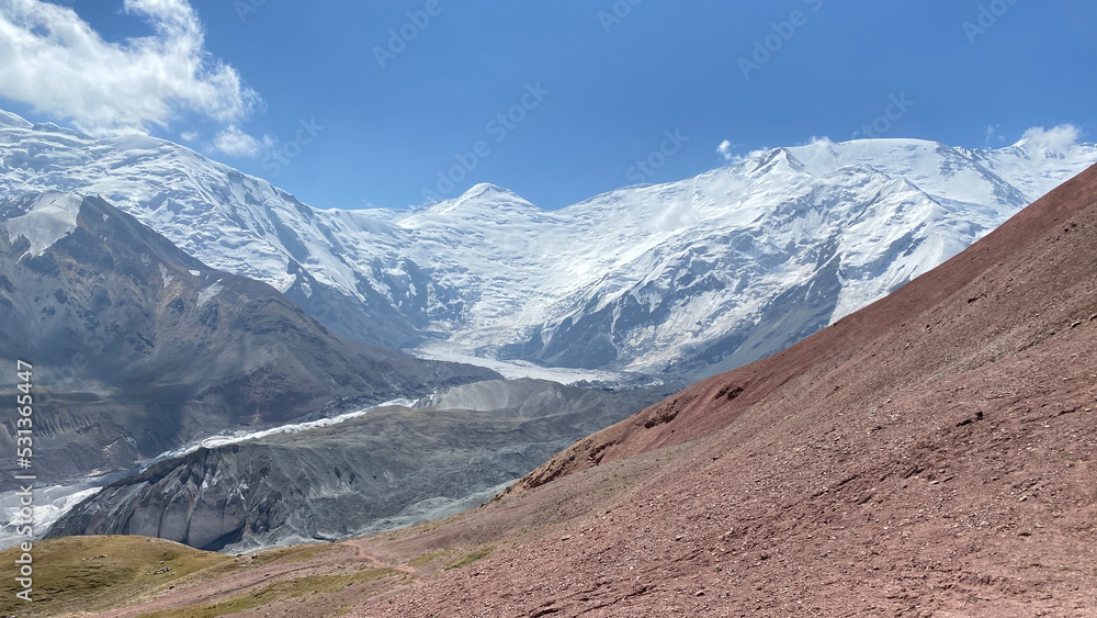 Beautiful view of Lenin Peak. The amazing nature of the Pamirs. Mountain landscape. Snow-covered peaks, colored rocks, glacier