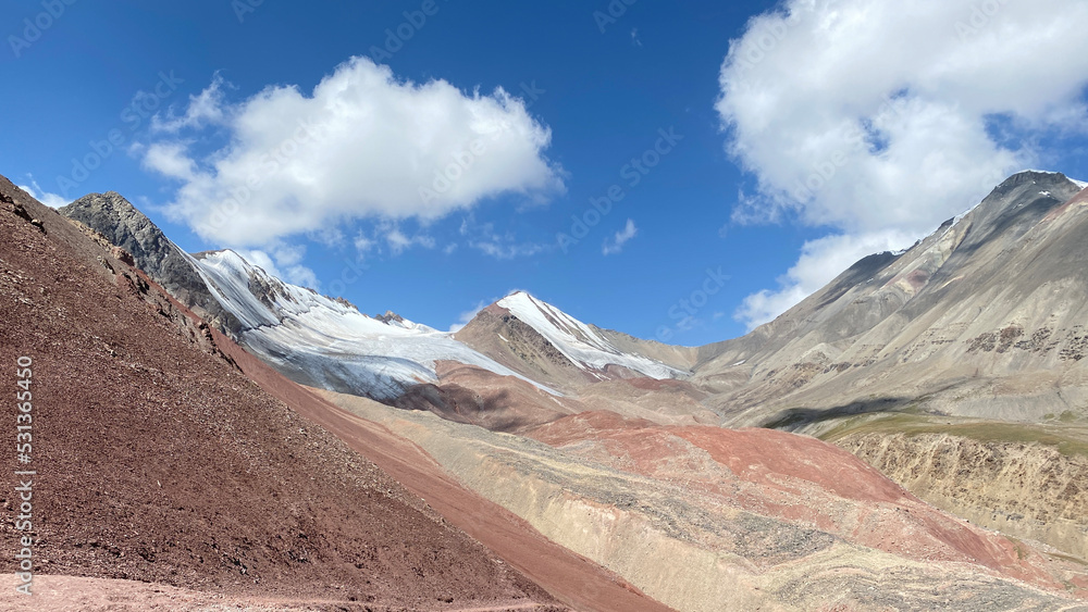 Colored rocks, snow-capped peaks and hills of Kyrgyzstan. The beautiful nature of the Pamirs.