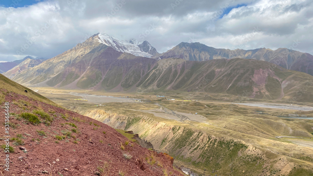 Green hills and slopes of Kyrgyzstan. Beautiful colorful rocky mountains. The amazing nature of the Pamirs. Summer mountain landscape.