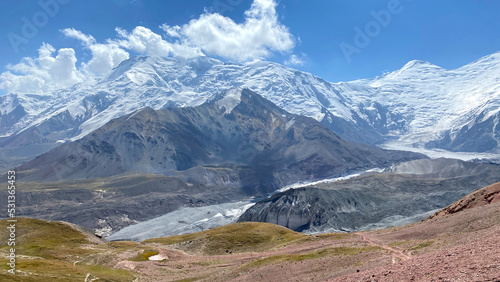 Snow-covered peaks, mountains and hills of Kyrgyzstan. The beautiful nature of the Pamirs. Panorama of amazing mountain landscape.