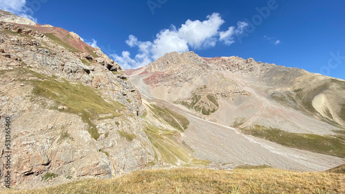 Colored rocky mountains, green slopes and hills of Kyrgyzstan. Beautiful summer mountain landscape.