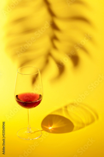 Glass of red wine on a yellow background.