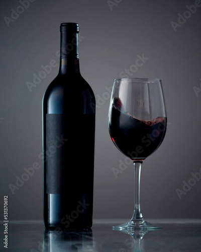 Bottle and glass with wine. Wine culture concept. Copy space, dark background, mock up. isolated on black background