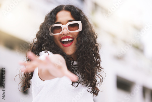 Designer sunglasses, luxury clothes and model being creative against city background, smile for summer and happy on weekend in town. Portrait of cool and trendy girl posing in fashion downtown photo