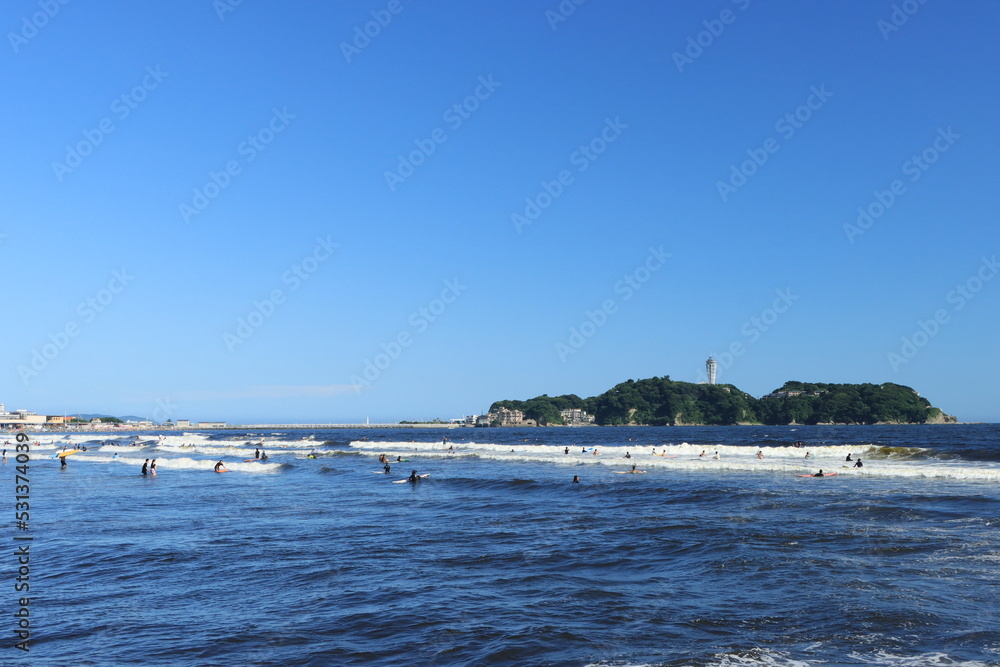 夏の江ノ島と海水浴やサーフィンを楽しむ人の風景
