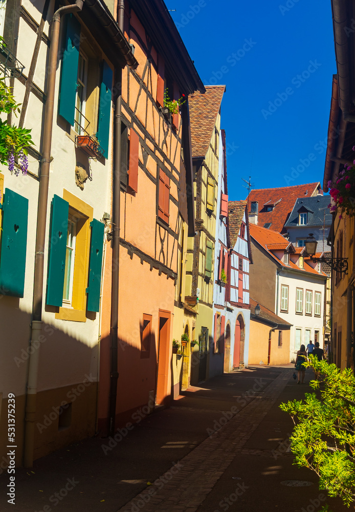 Obraz premium Picturesque summer cityscape of Colmar overlooking cobbled streets with typical residential townhouses on sunny day, France..