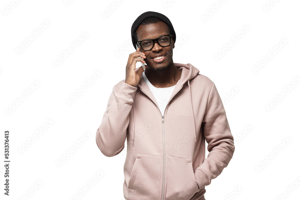 Horizontal picture of young attractive black man wearing casual clothes holding smartphone next to ear, looking sidewards Horizontal picture of young attractive black man wearing casual clothes holding smartphone next to ear, looking sidewards