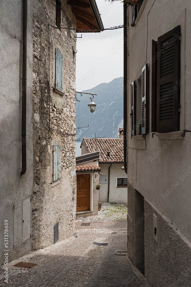 Old historic Italian architecture. Traditional European village rustic buildings. Flowers, wooden windows, shutters and pastel walls. Aesthetic summer vacation travel background - obrazy, fototapety, plakaty 