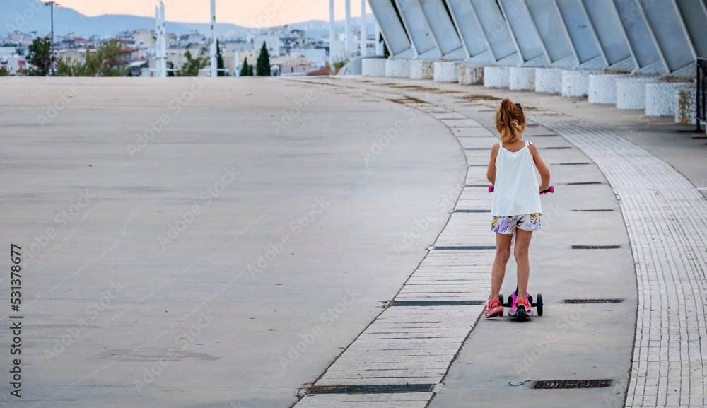 Child having fun and riding a scooter