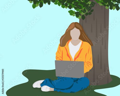 Faceless woman working on laptop in a public park under a tree 