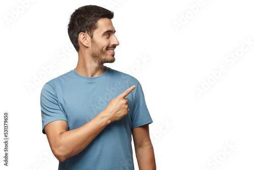 Casual dressed young man in blue t-shirt looking right, pointing with his finger