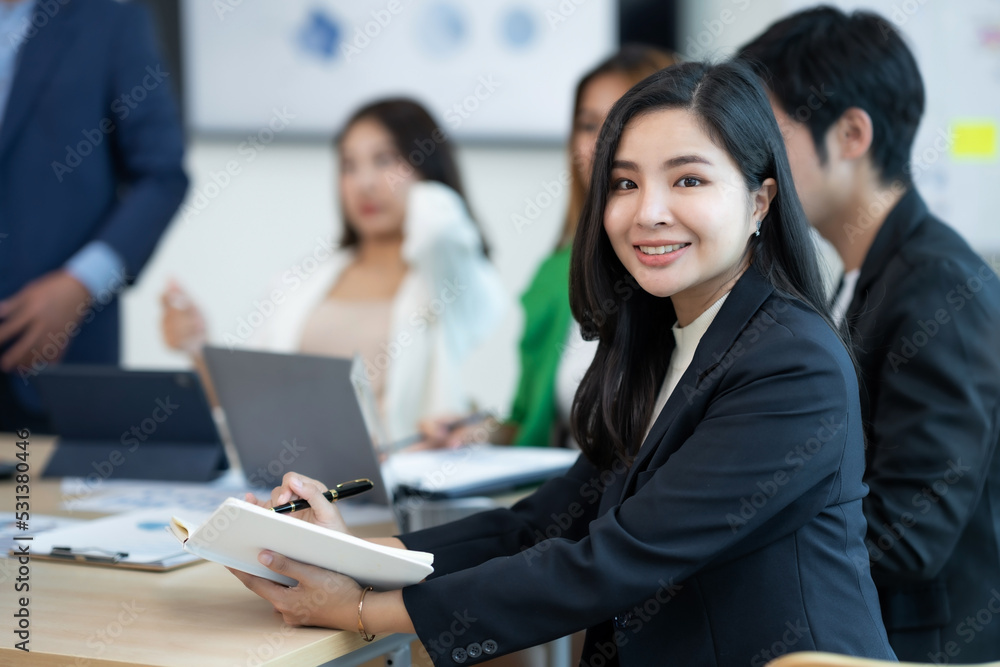 Confident and smart Asian businesswoman in her office smiling and looking at the camera in her office.