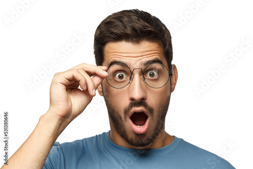 Young man in blue t-shirt shouting oh my god with open mouth, holding round glasses, surprised by low price and sales photo