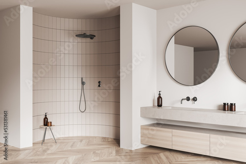 Corner view on bright bathroom interior with large round mirrors,