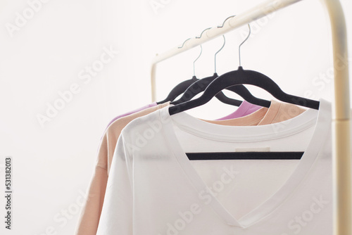 women's t-shirts on hanger on white background