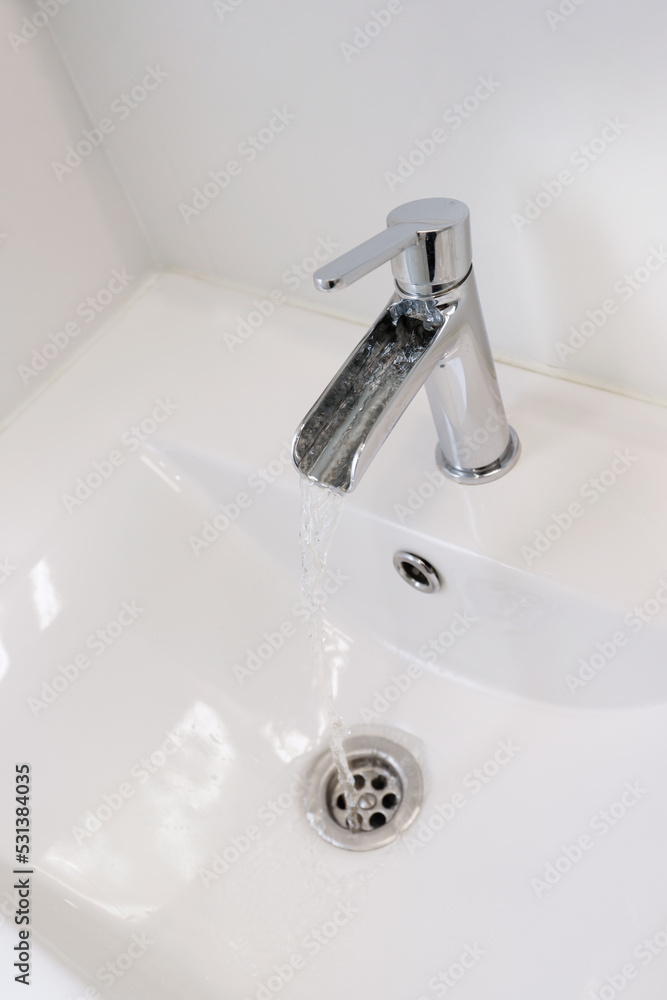 modern sink faucet with water flowing out of it modern sink faucet with water flowing out of it