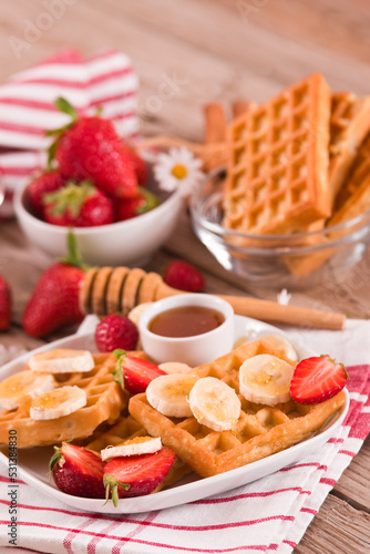 Waffles with strawberries, bananas and honey.