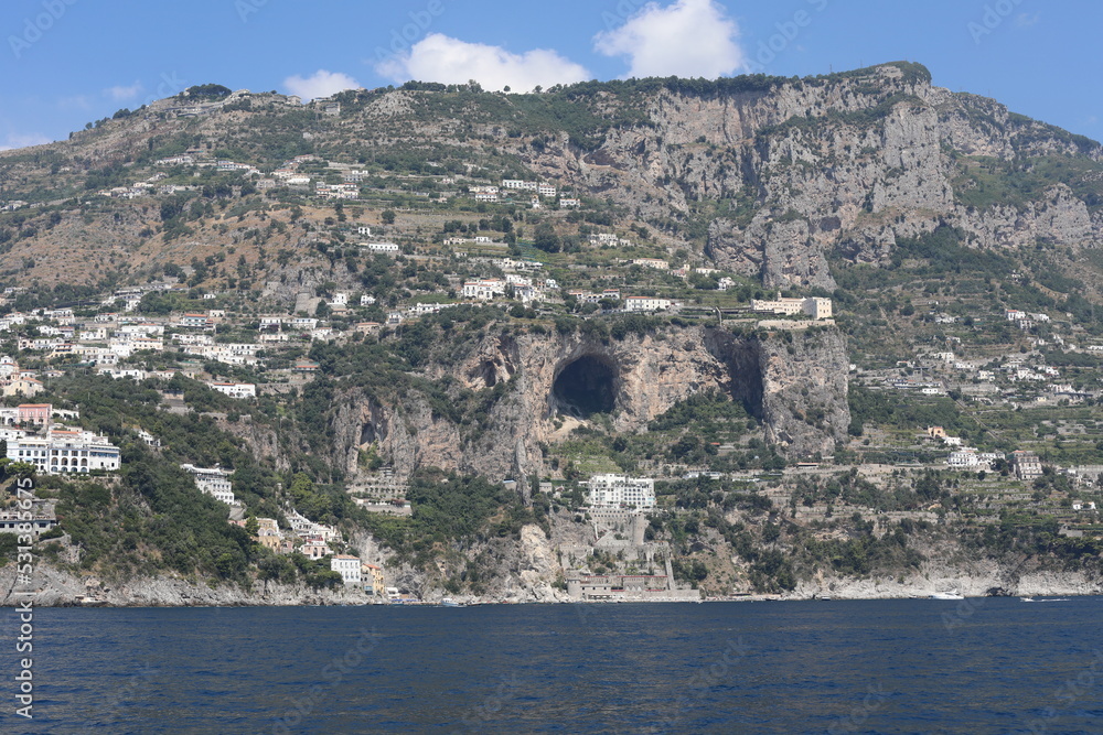 Scenic view from the sea to the castle near big natural cave in Amalfi Coast, Italy.