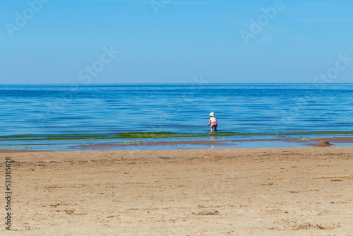 Two year old Toddler boy playing in the sea alone