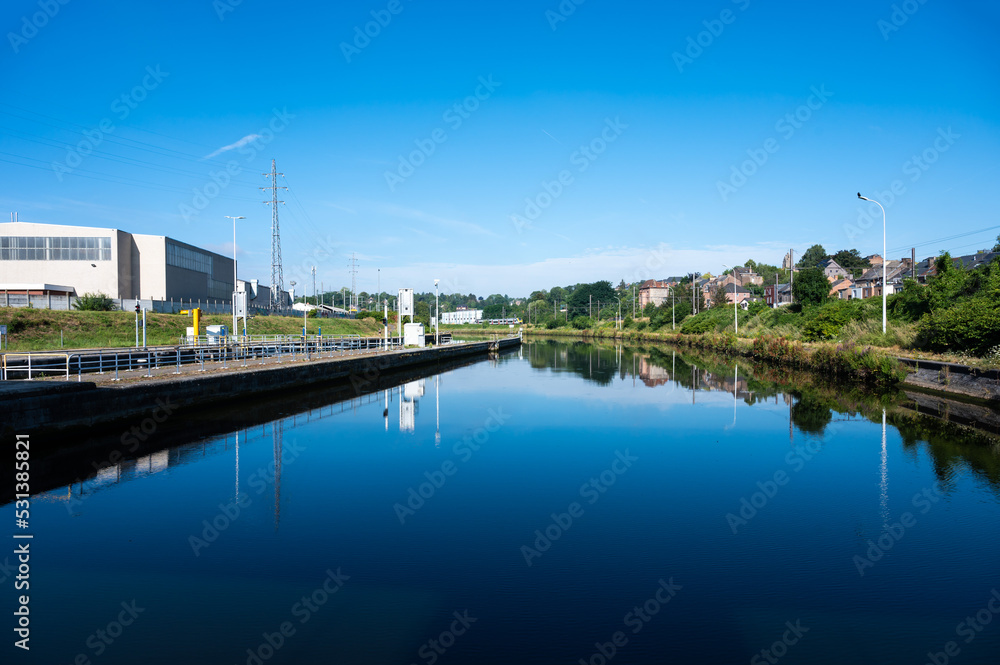 Namur, Wallon Region, Belgium, Industrial banks of the River Sambre reflecting in the blue water