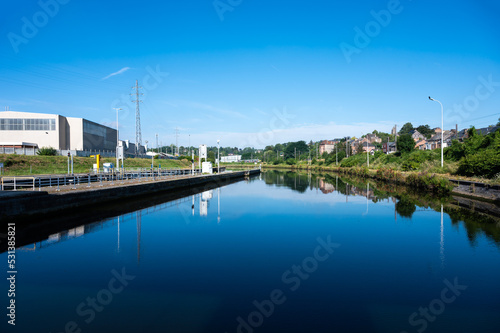 Namur, Wallon Region, Belgium, Industrial banks of the River Sambre reflecting in the blue water © Werner
