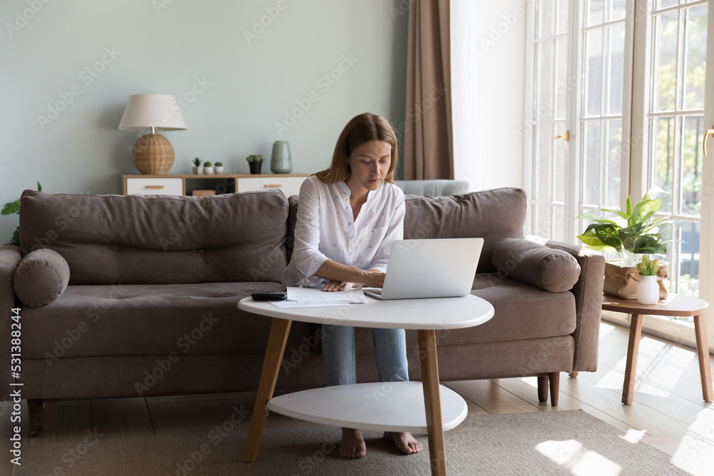 Serious millennial homeowner woman using online app on laptop for checking bills, paying mortgage, rent, insurance fees. Businesswoman, entrepreneur, freelance accountant working at home Serious millennial homeowner woman using online app on laptop for checking bills, paying mortgage, rent, insurance fees. Businesswoman, entrepreneur, freelance accountant working at home