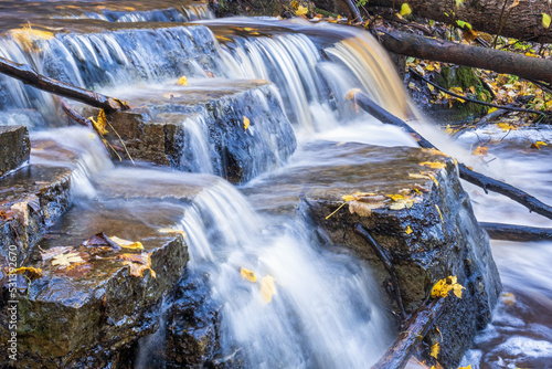 Waterfall in a creek with yellow autumn leaves © Lars Johansson