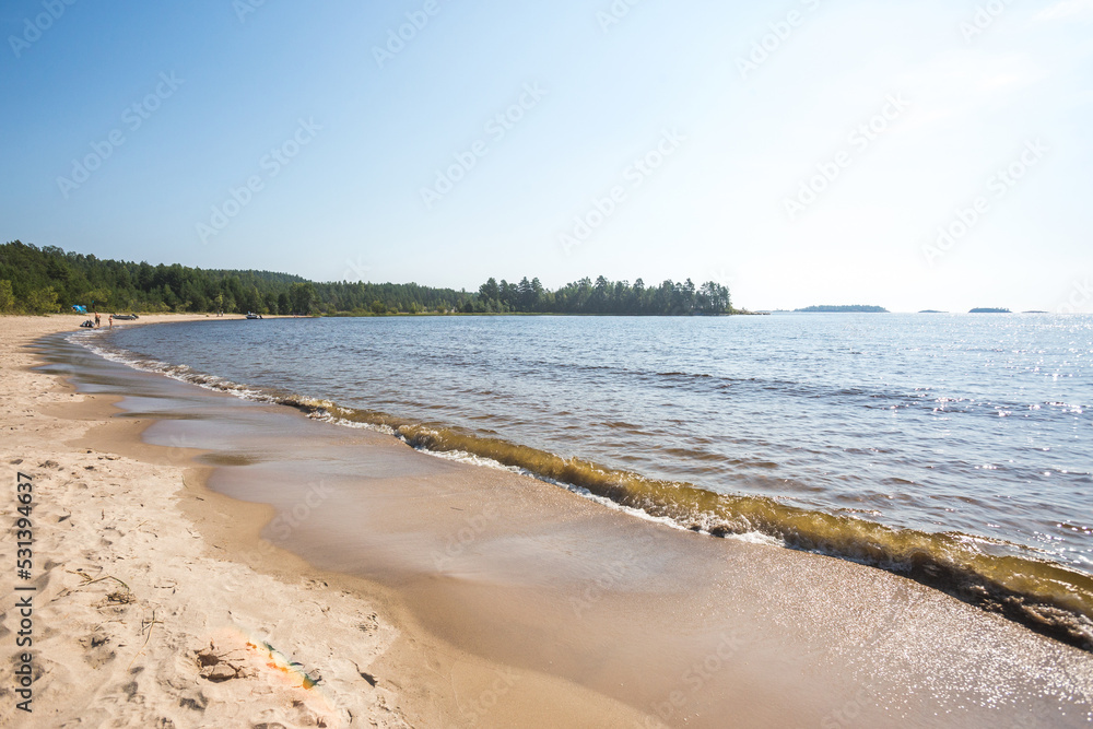 Sandy beach on the Koyonsaari Island. Ladoga Lake waves. Karelia Republic, Russia Sandy beach on the Koyonsaari Island. Ladoga Lake waves. Karelia Republic, Russia