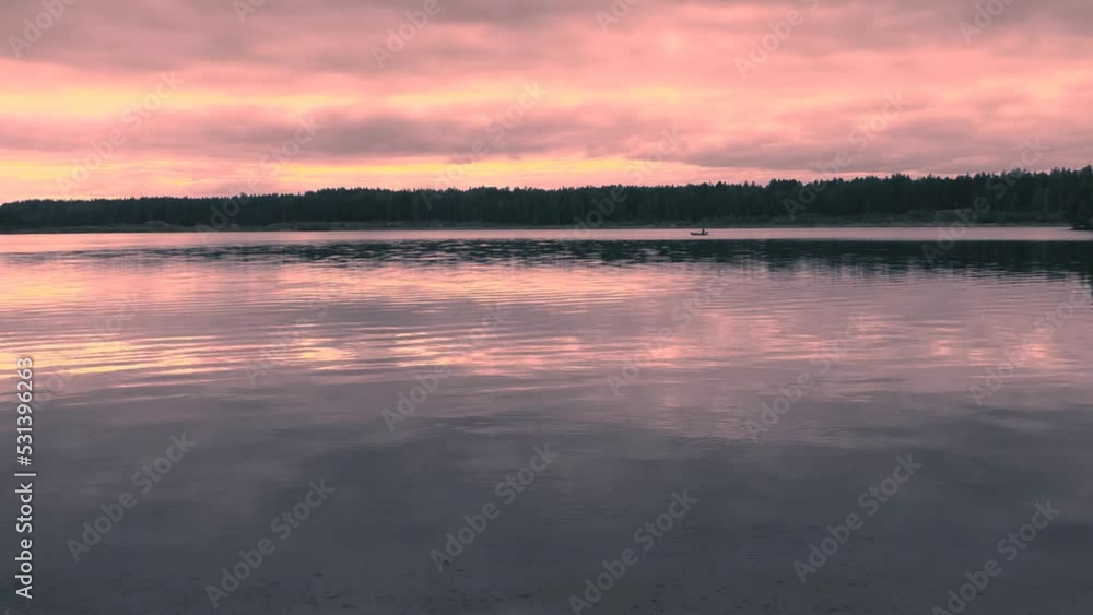 Sunset landscape on the lake and fisherman in a boat. Beautiful wildlife water of the North. Sunset landscape on the lake and fisherman in a boat. Beautiful wildlife water of the North.
