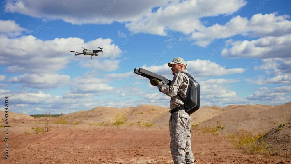 a man in a military uniform successfully uses a black anti-drone rifle in the desert a man in a military uniform successfully uses a black anti-drone rifle in the desert