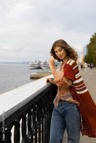 lifestyle elegant young woman on the embankment of a large river looks at the river