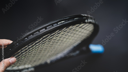 part of tennis racket head on black background, part of the game concept
