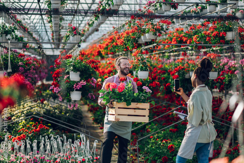 Multiracial florists working in a green house plant nursery © Zamrznuti tonovi
