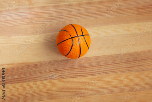 Basketball small ball close-up on a wooden parquet. Sports background with souvenir basketball. © Александр Ланевский