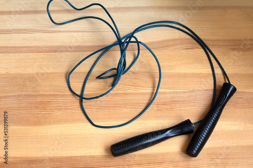 Sports jump rope on a wooden parquet. Healthy lifestyle. Morning exercises, physical culture, training.