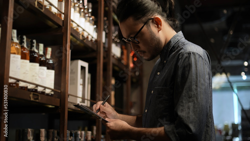 Night club concept of 4k Resolution. The bartender is checking the merchandise in the store. A group of specialized clubs that sell alcoholic beverages.