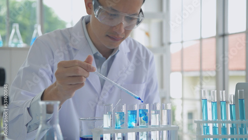 Research concept of 4k resolution. An Asian man dripping liquid into a test tube.