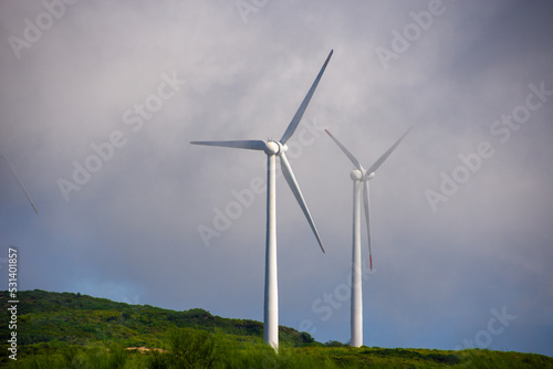 Two electric windmills in the top of a hill
