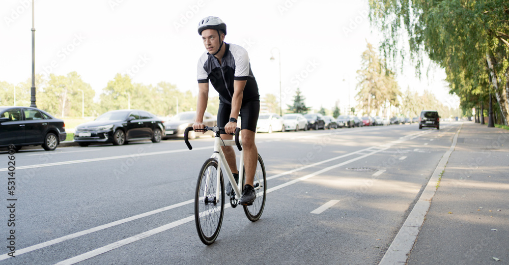 Obraz premium A male cyclist in a helmet rides a bicycle, training in the city.