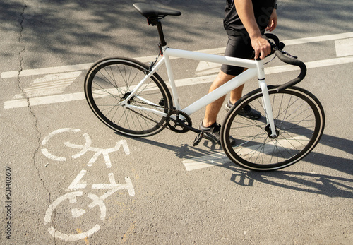 Bike path signs, male cyclist rides eco transport in the city.