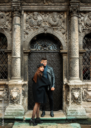 Lovely couple posing near a black door. Lviv, Ukraine November 2, 2019