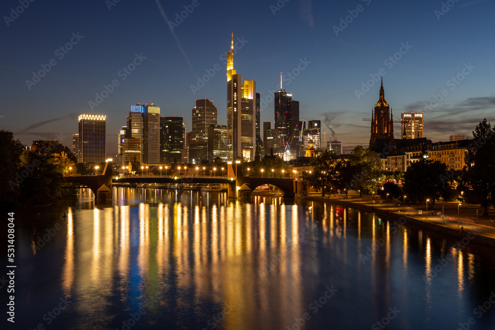 Frankfurt skyline and Alte Brücke bridge at night with reflection in the Main river in the foreground, taken from the Ignatz-Bubis bridge