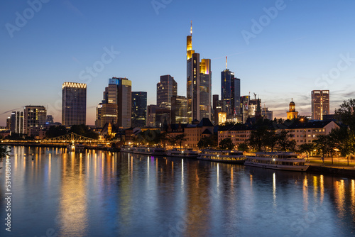 Frankfurt skyline and Eiserner steg bridge at night with reflection in the Main river in the foreground  taken from the Alte Br  cke bridge